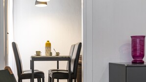 Ein Essbereich mit Tisch, Stühlen, einer Lampe und einer Vase.