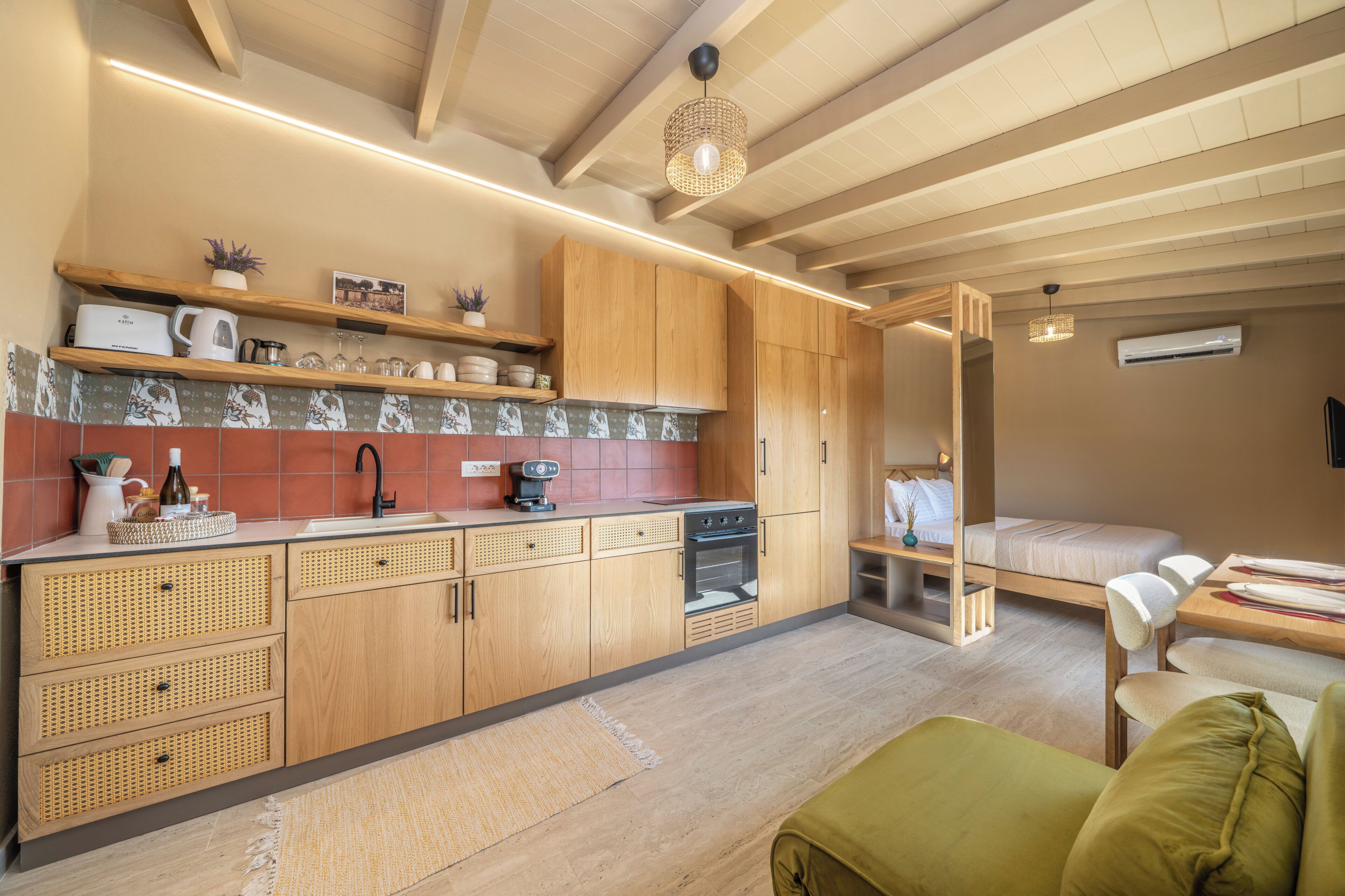 Una cocina compacta con armarios de madera, una cafetera y un horno empotrado.