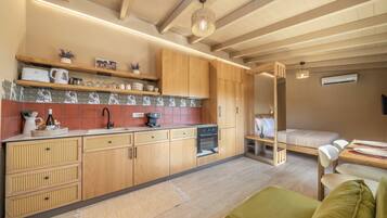 Una cocina compacta con armarios de madera, una cafetera y un horno empotrado.