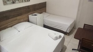A hotel room with a bed, a small table, and a chair. - Hotel Natal de Santos  (Santos)
