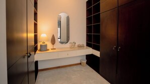 Un baño moderno con tocador, espejo y armarios de madera.