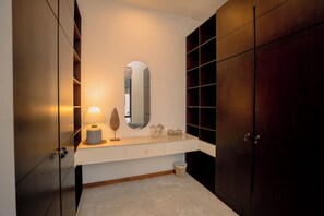 Un baño moderno con tocador, espejo y armarios de madera.
