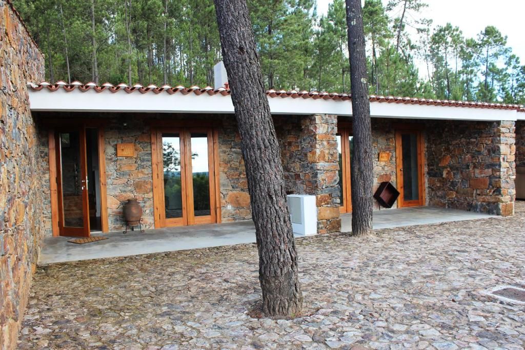 Un edificio de piedra con techo de tejas, puertas de madera y pared de piedra.