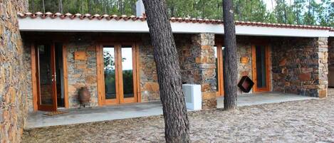 Un edificio de piedra con techo de tejas, puertas de madera y pared de piedra.