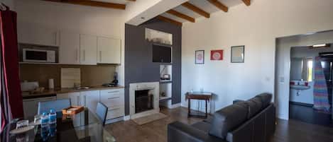 Una sala de estar moderna con chimenea, un sofá y un comedor con mesa de vidrio.
