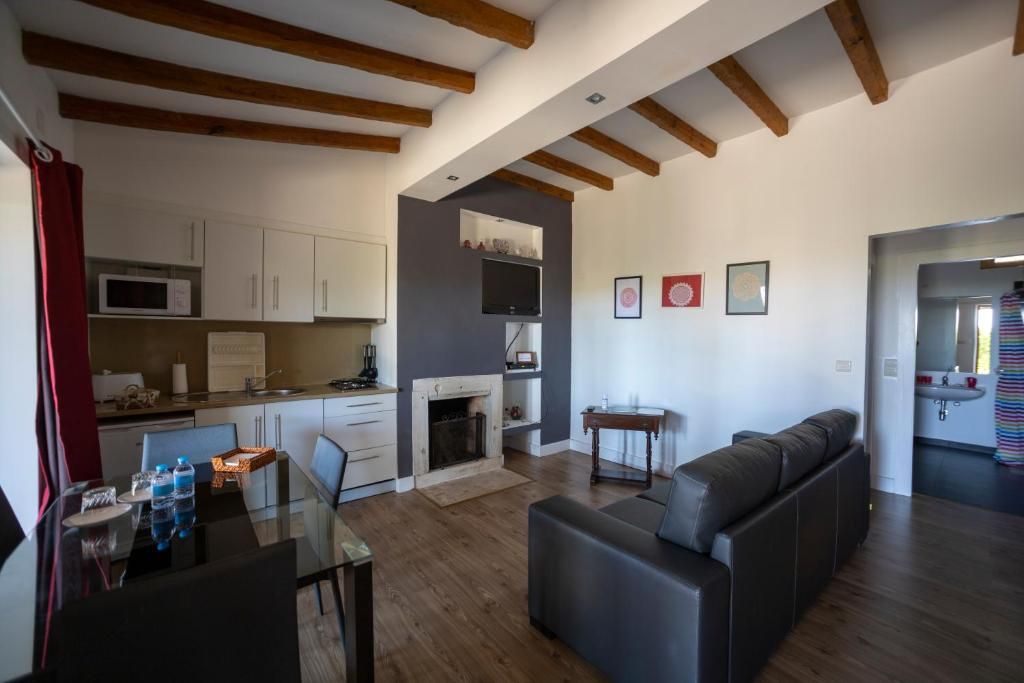 En moderne stue med et glasbord, en sofa og en pejs.