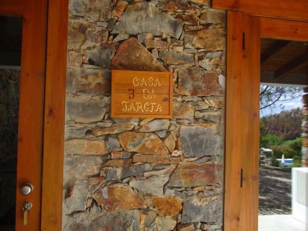 Eine Steinsäule mit einer Holztür und einem Schild, auf dem 'Casa 3 da Targea' steht.