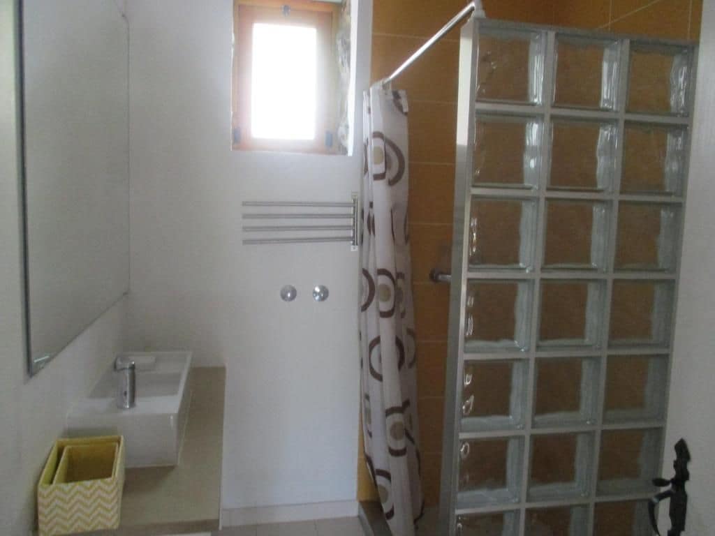 Un baño con ducha, lavabo y espejo.