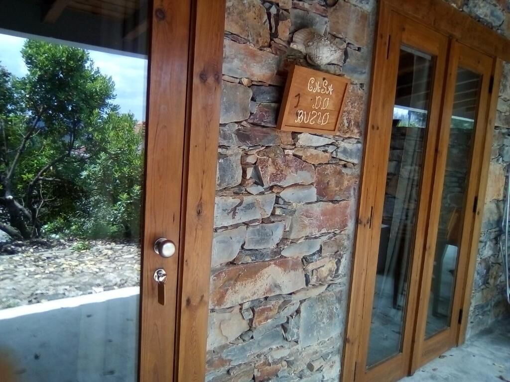 Parede de pedra com porta de madeira e uma placa.