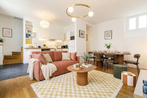 A modern living room with a sofa, coffee table, and dining area. - FurtiveStay - Champs Elysées - St Honoré - 3BDR 8P (Paris)