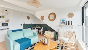 Ein modernes Wohnzimmer mit einer Couch, einem Couchtisch und Korbstühlen.