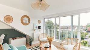 Ein modernes Wohnzimmer mit einer Couch, Sesseln, einem Couchtisch und einem großen Fenster mit Blick.