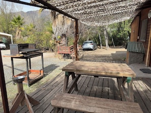 An outdoor patio with a grill, wooden table, and bench. - Oceana Suites Refugio del Maipo (San José de Maipo)