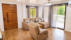 Ein Wohnzimmer mit einer Couch, einem Couchtisch und einer Holztür.