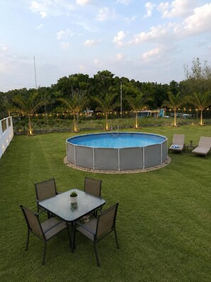 A backyard with a swimming pool, a table with chairs, and a grassy area. - Casa Cecilia Retreat w/pool Near PR’s Best Beaches (Aguada)