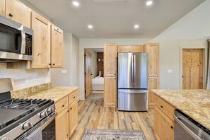 A kitchen with wooden cabinets, a stainless steel refrigerator, a microwave, and a stove. - Brand New Cozy Getaway - Mountain Views + Firepit (Buena Vista)