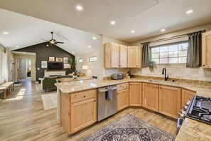 A modern kitchen with wooden cabinets, a granite countertop, and a built-in dishwasher. - Brand New Cozy Getaway - Mountain Views + Firepit (Buena Vista)