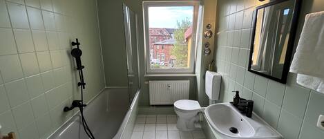 Un baño con bañera, inodoro y lavamanos.
