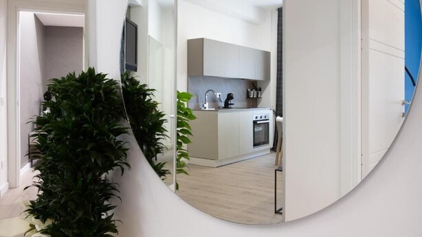 A modern kitchen with white cabinetry, a built-in oven, and a sink.