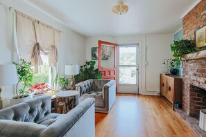 A living room with a sofa, a coffee table, and a fireplace. - The Mariposa (Staunton)