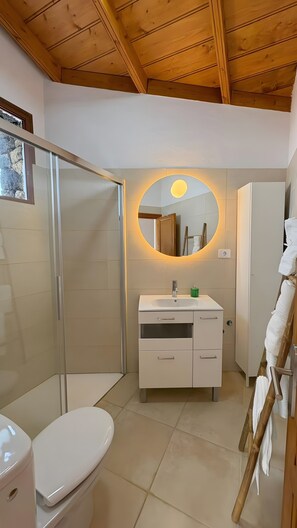 A modern bathroom with a shower, toilet, and vanity. - Holiday Home 'Lagar De Elba' with Sea View, Private Pool and Wi-Fi (Las Manchas)
