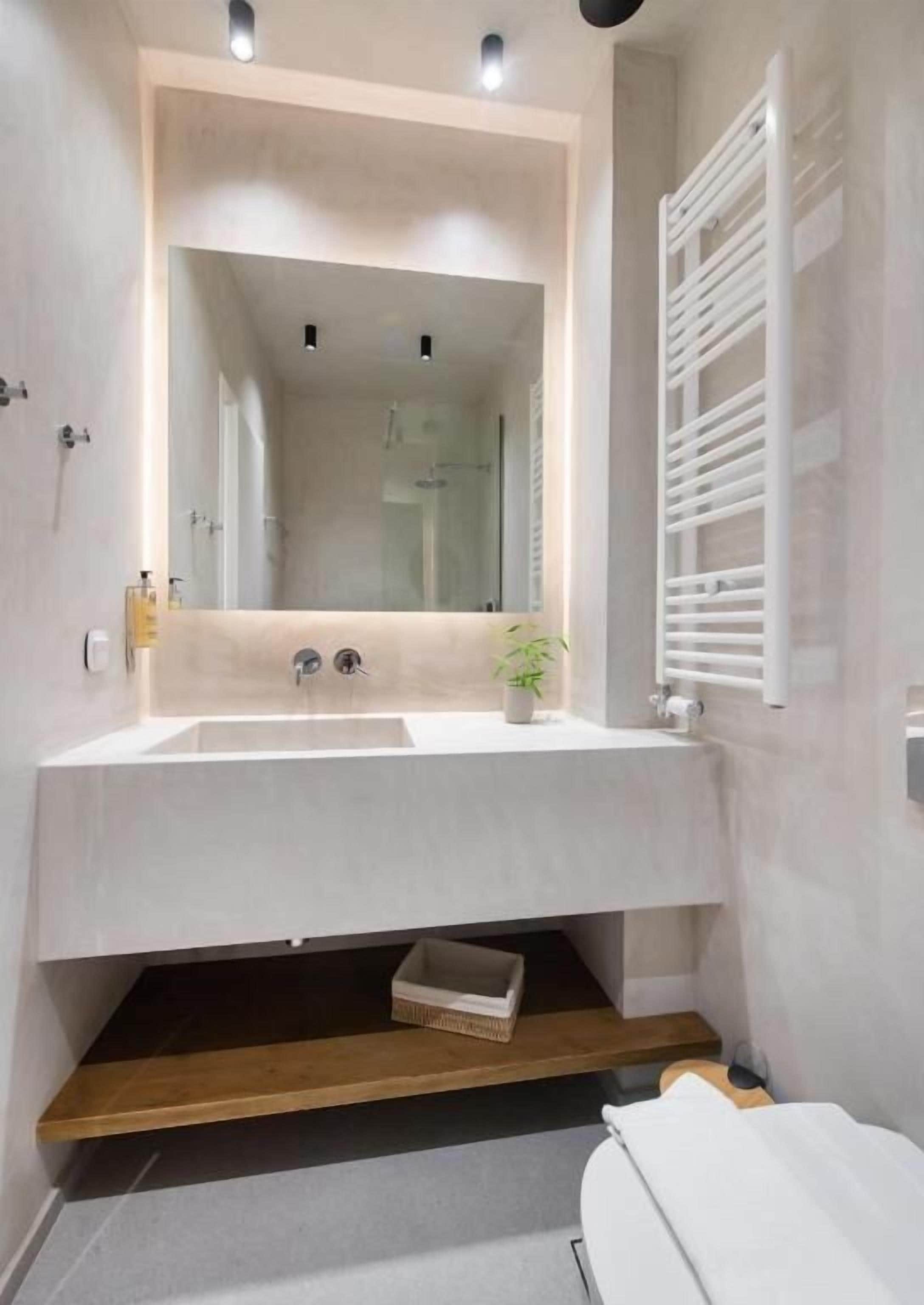 A bathroom with a white sink, mirror, and towel rack.