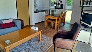 Un espacio habitable compacto con comedor, cocina y zona de estar.