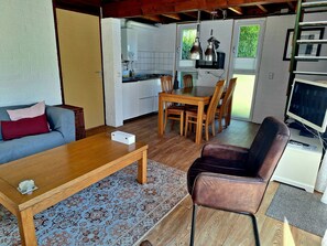 A compact living space with a dining area, kitchen, and seating area.