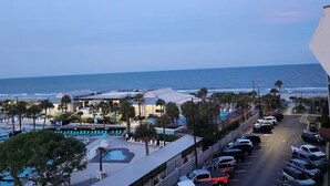 Um hotel à beira-mar com piscina, estacionamento e vista para o oceano.
