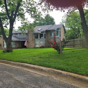 A two-story house with a brick facade, a front lawn, and a wooden fence. - Private Pool + Hot Tub Pet-Friendly Lake Texoma Home w/ Boat Parking (Pottsboro)