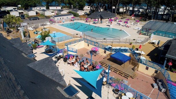 A pool area with multiple swimming pools, sun loungers, and umbrellas. - Rent a new mobile home at the 4-star Les Charmette campground—fully equipped (Les Mathes)