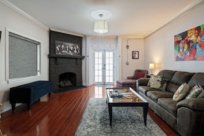 A living room with a fireplace, a sofa, a coffee table, and a rug.