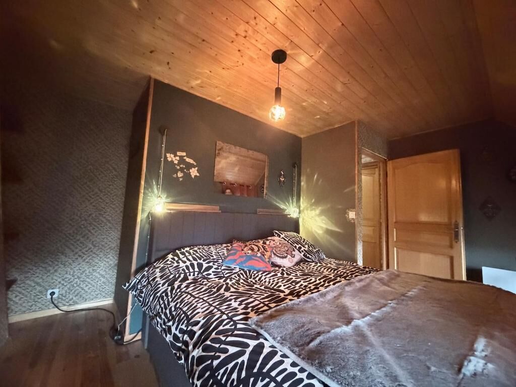 Ein Schlafzimmer mit einem Bett, Holzboden und einer Tür.