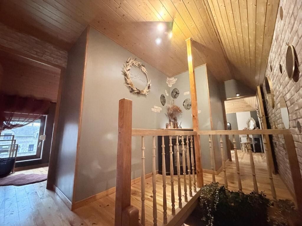 Un intérieur en bois avec un escalier, un mur décoré d’une guirlande et une fenêtre.