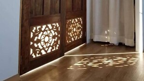 Un pasillo con puertas de madera y una cortina blanca.
