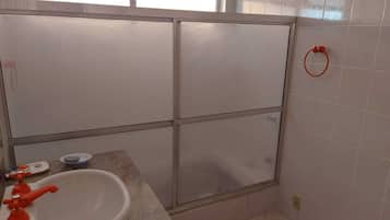 Een douche, een bubbelbad, zeep, toiletpapier