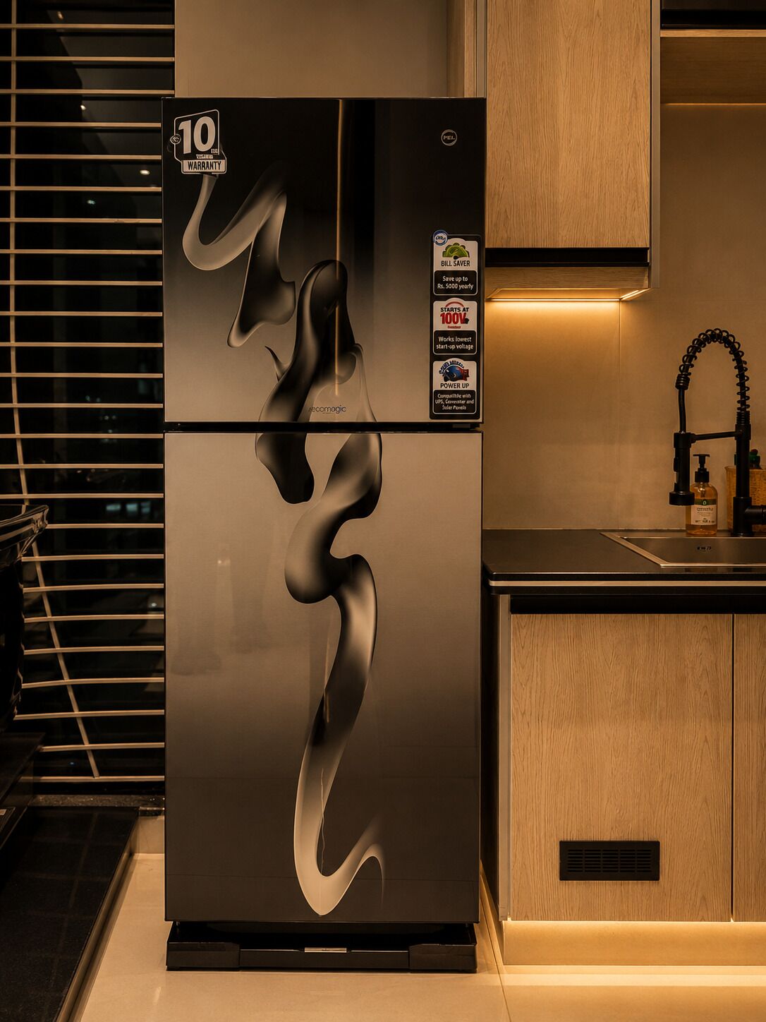 Una cocina moderna con un refrigerador de acero inoxidable que presenta un diseño en espiral único, un gabinete de madera y un grifo negro.