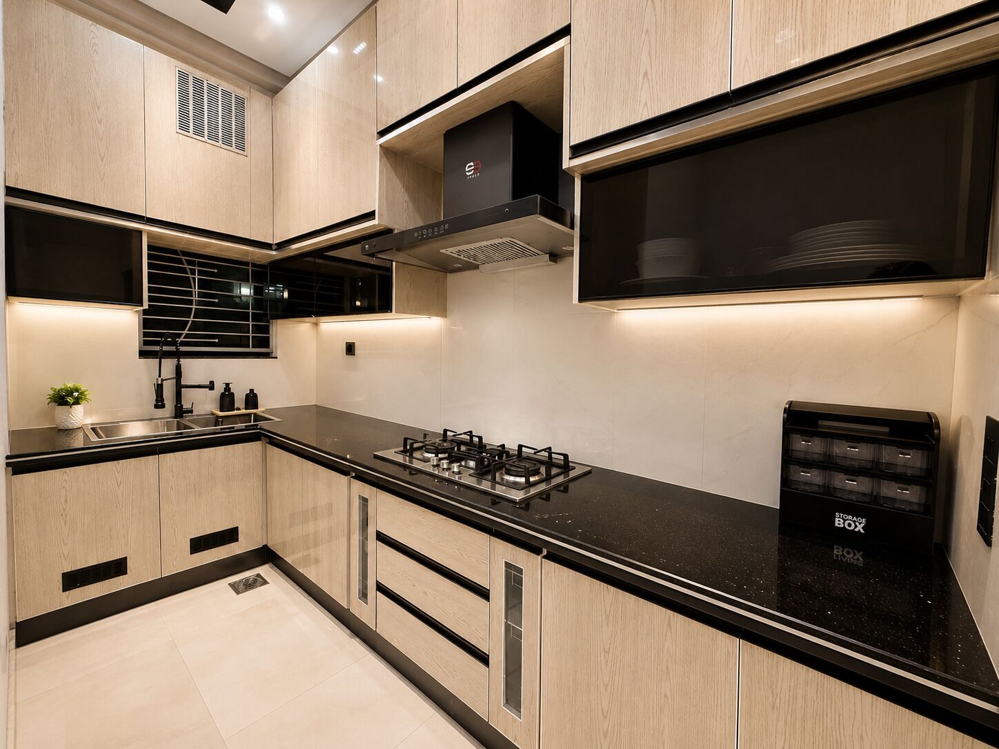 Une cuisine moderne avec un plan de travail noir, des meubles de rangement en bois, une cuisinière à gaz et une hotte aspirante noire.