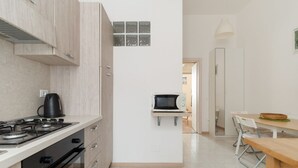 A compact kitchen with a stove, microwave, and cabinets. - Comfortable 35m2 apartment, ideal for up to 5 people, located on the second floor of a building with lift.The accommodation is located in the Porta Romana district in a strategic position, a stone's throw from the Lodi Tibb M3 stop and the Porta Roman (Milan)