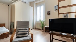 A room with a bed, a chair, a television, a radiator, and a window with curtains. - Comfortable 35m2 apartment, ideal for up to 5 people, located on the second floor of a building with lift.The accommodation is located in the Porta Romana district in a strategic position, a stone's throw from the Lodi Tibb M3 stop and the Porta Roman (Milan)