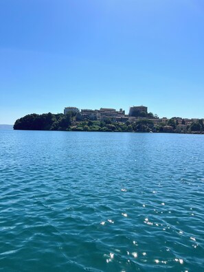 A coastal town with buildings on a small island, calm water, and clear skies.