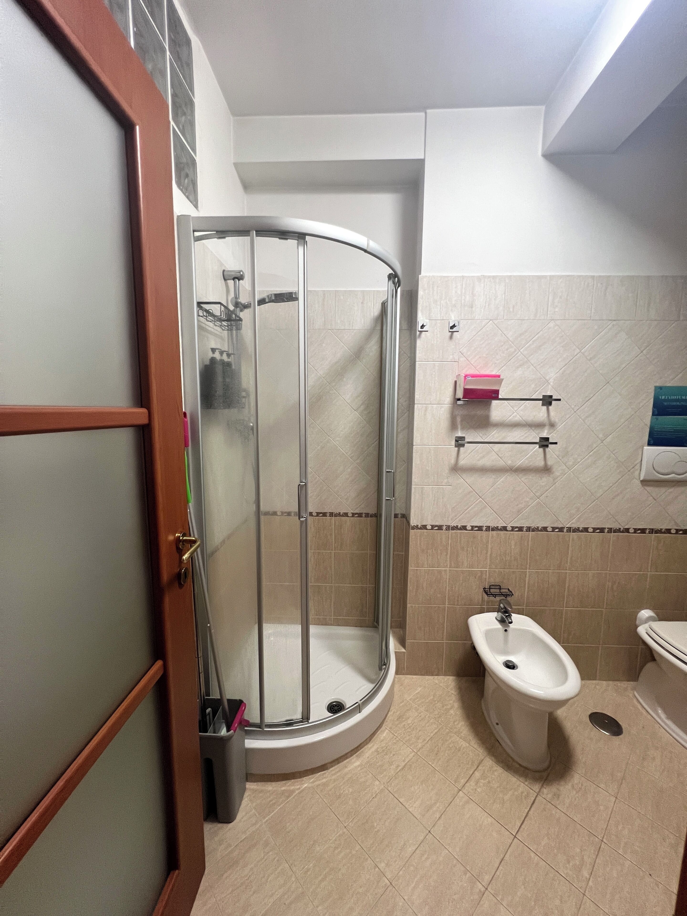 Ein Badezimmer mit einer Duschkabine, einem Bidet und einer Toilette.