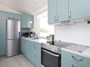 Een moderne keuken met een roestvrijstalen koelkast, een oven en een inbouwfornuis.