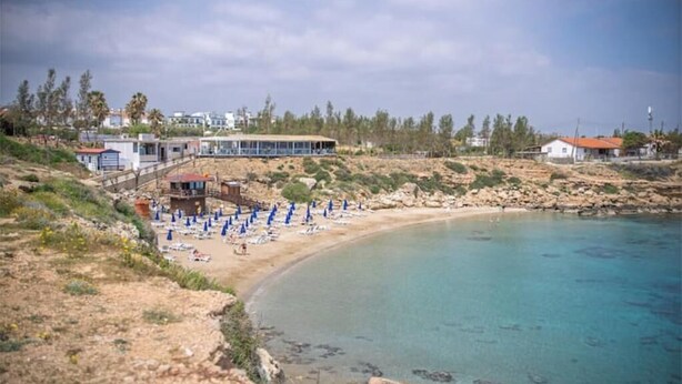 A coastal area with a beach, a building with a covered area, and a rocky shoreline. - Mambo Private Villa w/ Pool by the Beach (Paralimni)