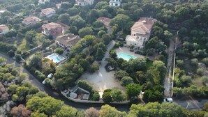 An aerial view of a residential area with houses, a swimming pool, and a road.