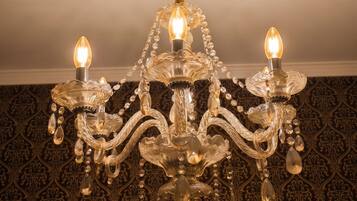 Un candelabro con tres luces, un tirador de metal retorcido y detalles de cristal.