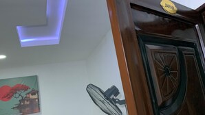 Ein Hotelzimmer mit einem Bett, einem Wandventilator, einer Deckenleuchte und einer Tür mit der Aufschrift 'JAPAN'.