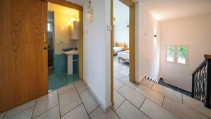A hallway with a wooden door, a bathroom with a sink and toilet, and a bedroom with a bed and window. - Seaview Paradise Villa w/ pool & jacuzzi in Pomos (Pomos)