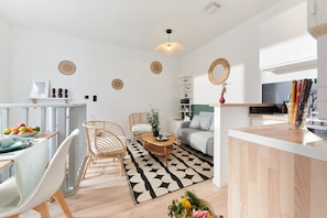 A modern kitchen with a central island, a dining area with a table and chairs, and a living space with a sofa and a coffee table. - Univers 1-Bedroom Apartment, Gym, 2' from Lille (Ronchin)