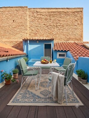 A patio with a table and chairs, a small window, and a view of a brick wall. - Unique! in the HEART of Athens Entire Building Apartment (Athina)